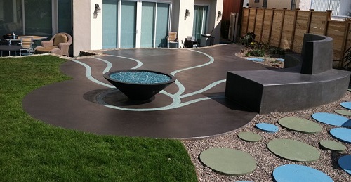Poured concrete patio with gray microtopping and curved concrete bench